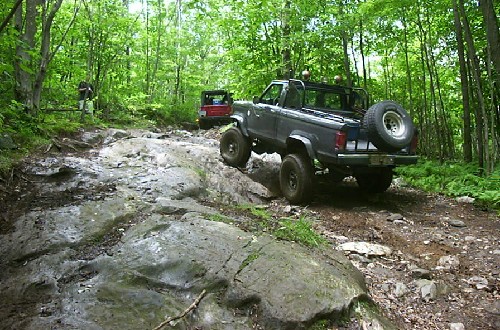 Off-road trucks navigating rocky trail