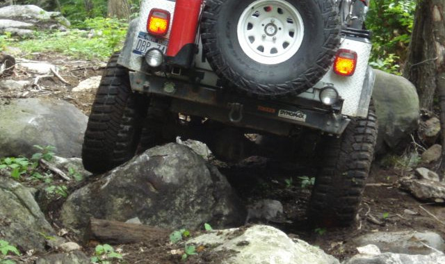 White Jeep traversing rocky terrain