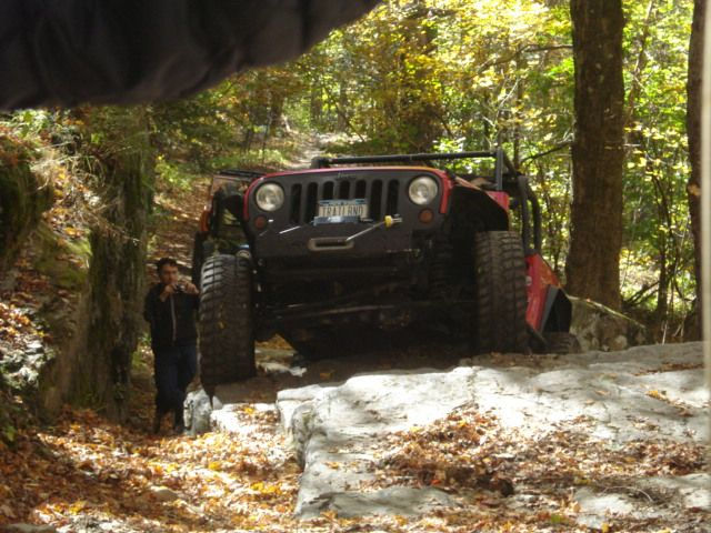 Red Jeep stuck on trail, autumn leaves
