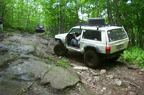 White Jeep navigating rocky trail