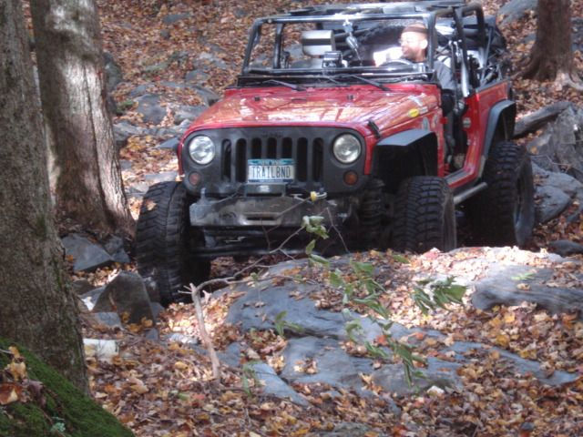 Red Jeep navigating rocky trail