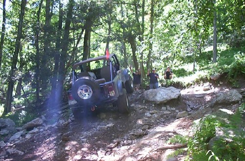 Jeep navigating rocky trail, people watching