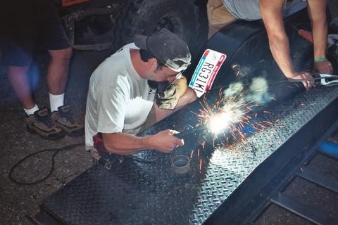 Welder working on metal, sparks fly