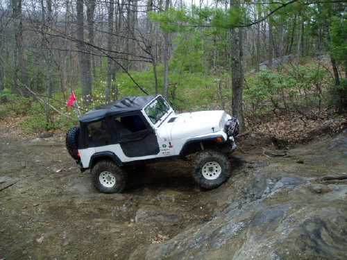 White Jeep traversing rocky terrain
