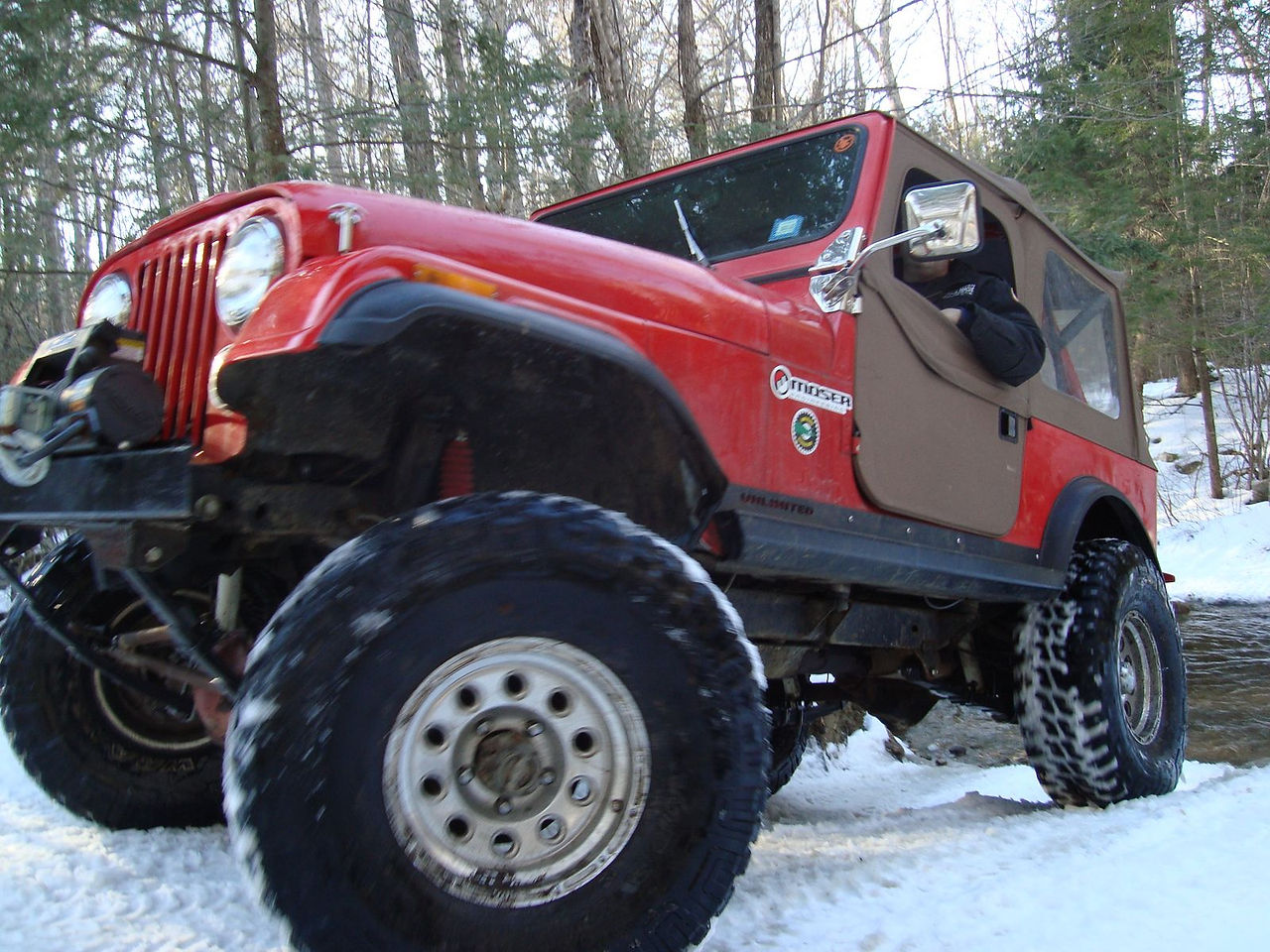 Person driving red Jeep CJ in snow