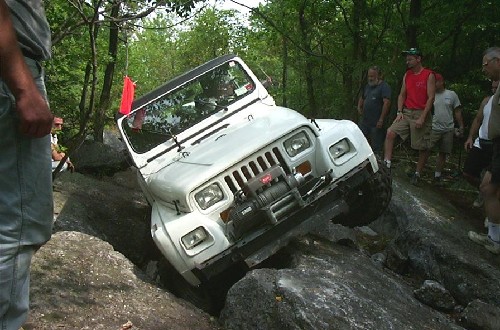 White Jeep navigating rocky terrain
