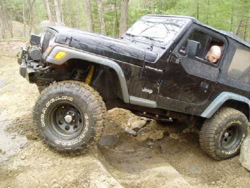 Black Jeep Wrangler navigating rocky terrain