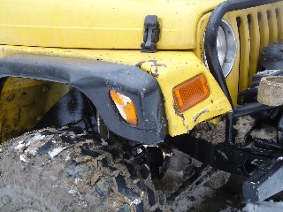 Muddy yellow Jeep Wrangler, off-road