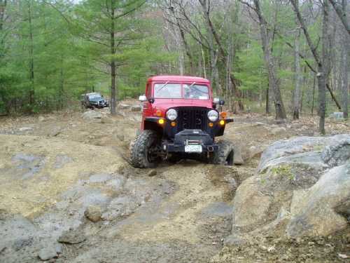 Red Jeep navigating rocky terrain
