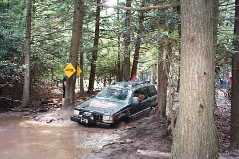 Jeep stuck in mud, caution sign