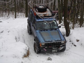 Blue Jeep Cherokee navigating snowy trail