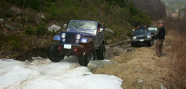 Purple Jeep and another vehicle off-roading in snowy conditions