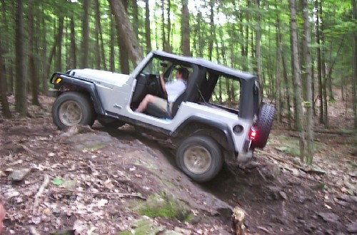 Person driving Jeep on rocky trail