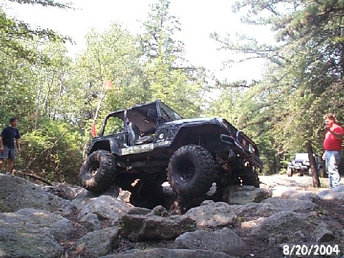 Black Jeep traversing rocky terrain