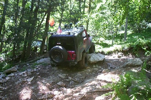 Red Jeep navigating rocky trail