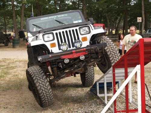 White Jeep Wrangler overcoming obstacle course