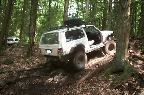 White Jeep Cherokee off-roading on rocky trail