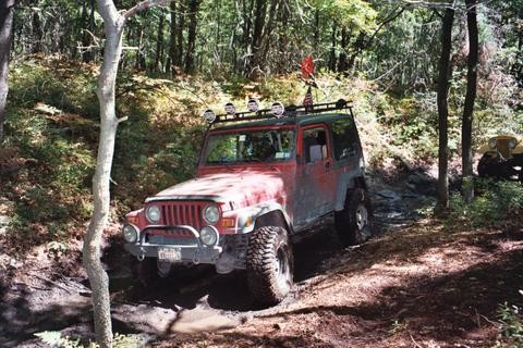 Red Jeep traversing Carnage Hill's challenging terrain, Long Island Off Road