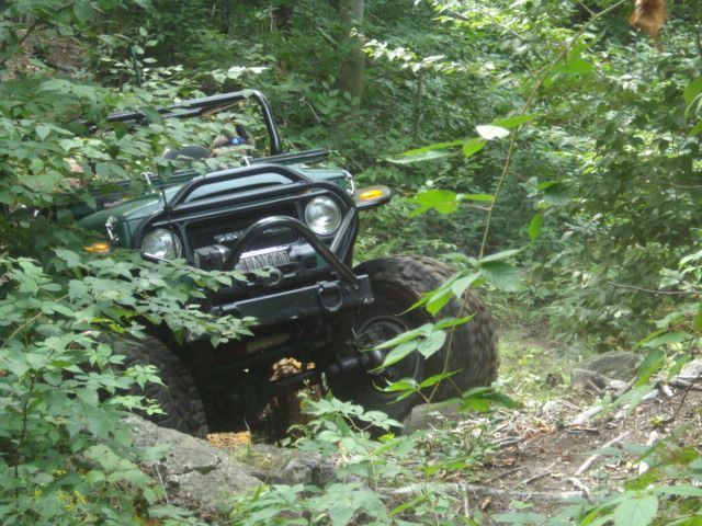 Green Jeep navigating rocky trail