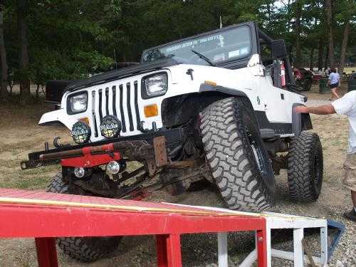 White Jeep Wrangler navigating off-road obstacle