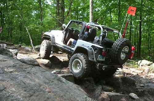 White Jeep navigating rocky terrain