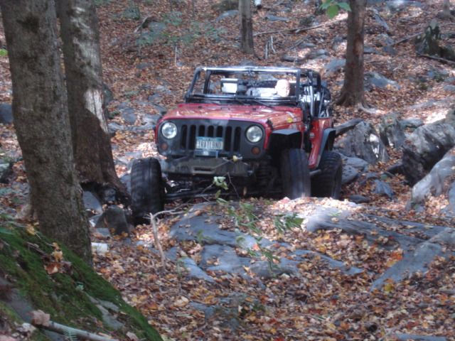 Red Jeep navigating rocky trail
