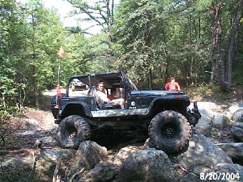 Black Jeep on rocks, two people inside