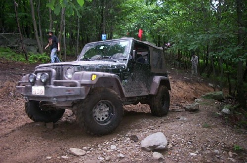 Black Jeep traversing muddy trail