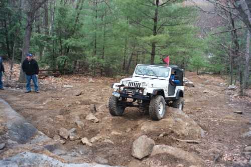 White Jeep navigating rocky terrain