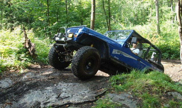 Blue Jeep traversing a rocky trail