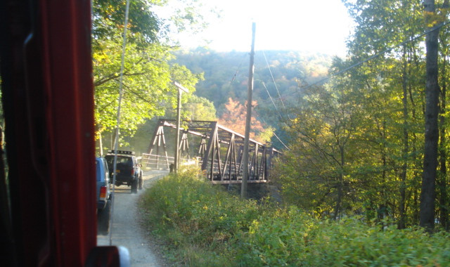 Off-road vehicles approaching rustic bridge