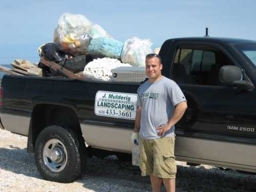 Man with landscaping truck full of trash