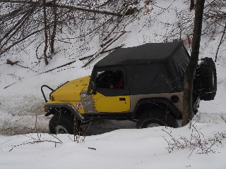 Yellow Jeep navigating snowy terrain