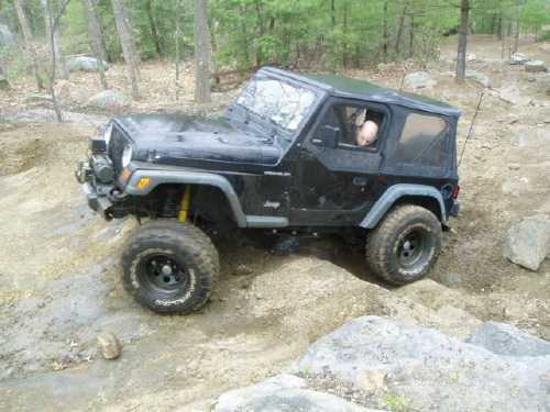 Black Jeep Wrangler navigating rocky terrain