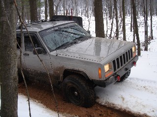 Gray Jeep Cherokee in snowy woods
