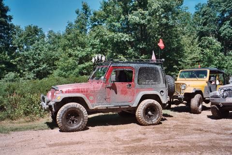 Muddy red Jeep Wrangler, off-roading
