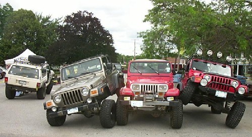 Three lifted Jeeps parked outdoors