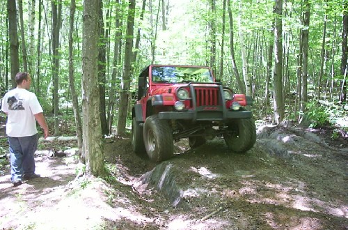 Red Jeep on wooded trail