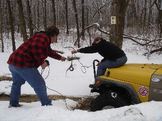 Women pulling jeep from snow