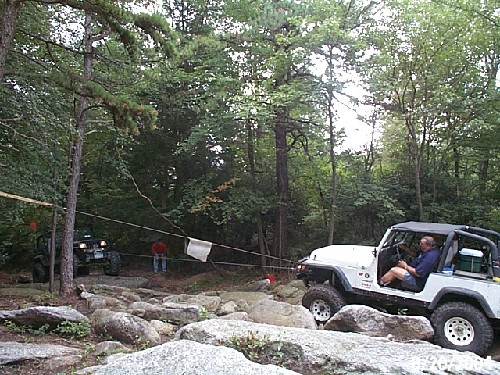 White Jeep being winched over rocks, Long Island Off Road