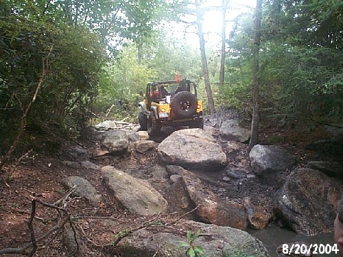 Yellow Jeep navigating rocky trail