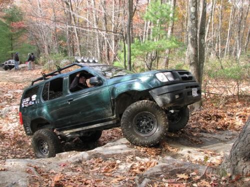 Green SUV on rocky trail