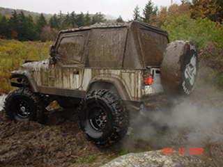 Muddy Jeep traversing terrain
