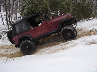 Red Jeep navigating snowy terrain