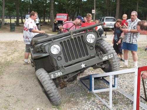 Vintage Jeep 2-381 on ramp, spectators watching