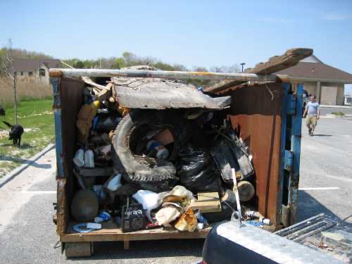 Overfilled dumpster with assorted trash and debris