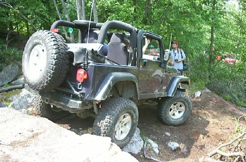 Black Jeep Wrangler off-roading on rocks