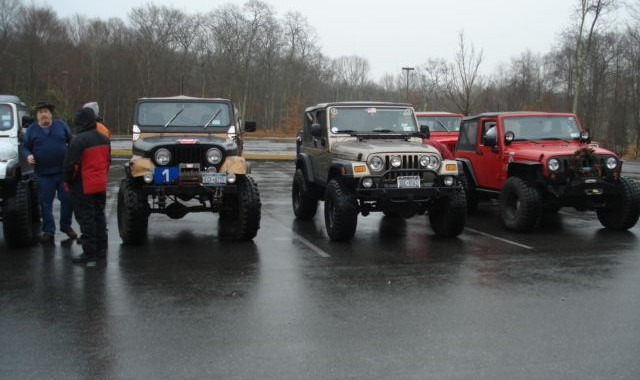 Jeeps parked in a parking lot on a rainy day