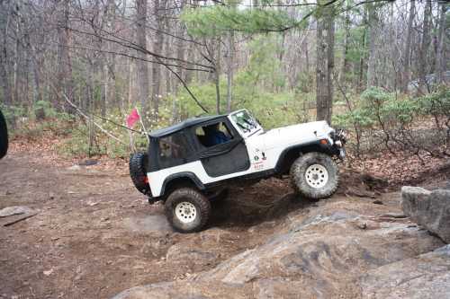 White Jeep navigating rocky terrain