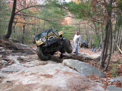 Yellow Jeep navigating rocky terrain